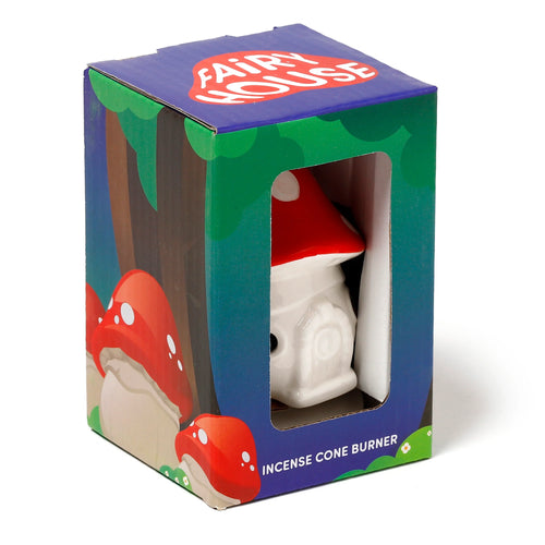 Angled view of a Ceramic Fairy Toadstool House incense cone burner, partially visible in its colourful retail packaging. The white ceramic base and red spotted cap of the toadstool burner are seen through the box's window. The packaging features woodland graphics and text 'Fairy House' and 'Incense Cone Burner'.