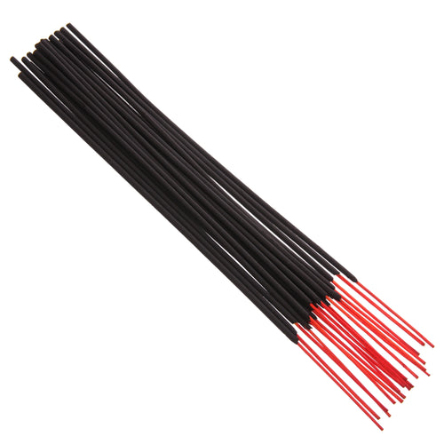 Angled view of several black incense sticks, showing their visible red wooden core ends.