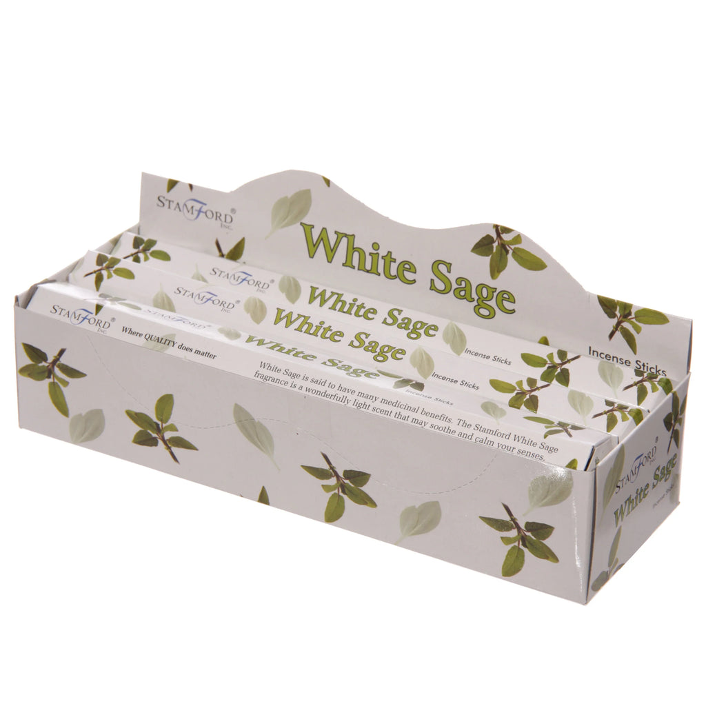 Elevated, angled view of a white display box containing six packets of White Sage incense sticks. The box and individual packets are white with a green leaf design, displaying 'White Sage' and 'Incense Sticks' text.