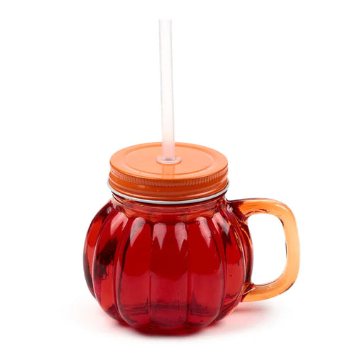 Front-side view of pumpkin-shaped glass drinking jar with red liquid inside, an orange lid, clear straw, and orange handle.