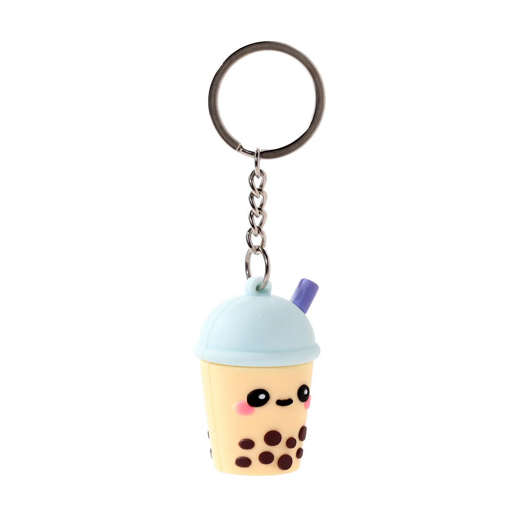 Front view of a 3D PVC bubble tea keyring featuring a light yellow cup with brown boba pearls, a light blue domed lid, a purple straw, and a cute smiling face with black eyes and pink cheeks, attached to a silver-coloured metal chain and split ring.