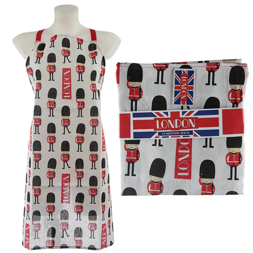 Front view of a white London Guardsman apron with red straps, displayed on a mannequin, featuring a repeating pattern of red-coated Guardsmen and 'LONDON' text, shown alongside the same apron folded and packaged with a Union Jack themed band.