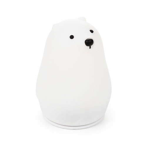 Angled view of a white polar bear sleep lamp night light, featuring black eyes and nose.