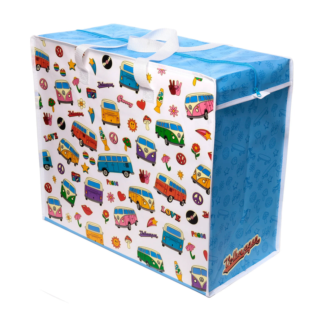 Angled view of a white laundry and storage bag, adorned with a multi-coloured retro pattern depicting Volkswagen VW T1 Camper Buses, peace signs, flowers, and 'LOVE' text. It features a blue zippered top and a matching blue side with outlined motifs, along with white fabric carrying handles.