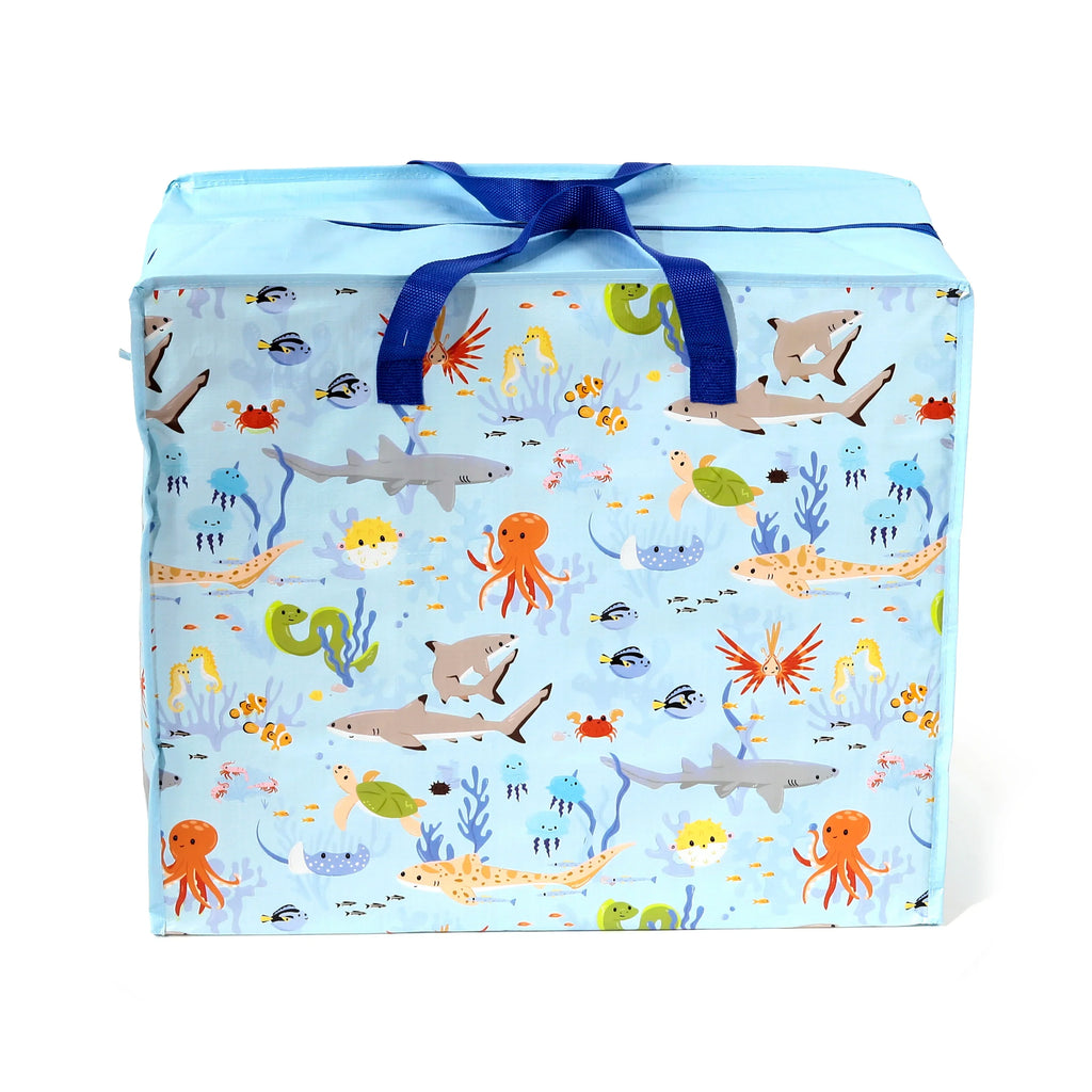 Front view of a light blue laundry and storage bag, featuring a colourful cartoon marine life print. The design includes sharks, octopuses, turtles, seahorses, and various fish, with dark blue carry handles tied at the top.