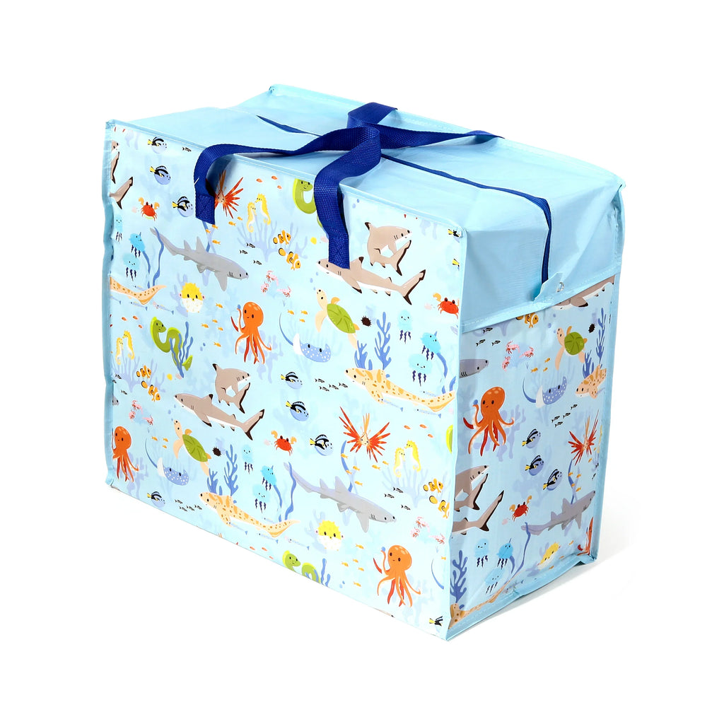 Angled view of a light blue laundry and storage bag with a colourful marine animal pattern, depicting sharks, octopuses, turtles, and fish, with dark blue webbing handles.