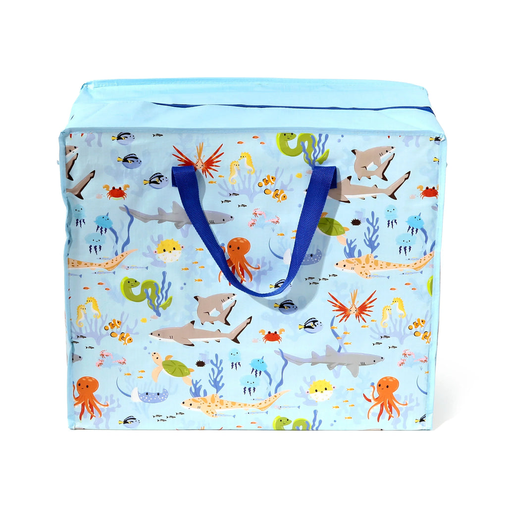 Front view of a light blue laundry and storage bag, adorned with a colourful undersea creature pattern including sharks, octopuses, jellyfish, and clownfish. It features dark blue fabric handles and a light blue top with a contrasting dark blue trim.