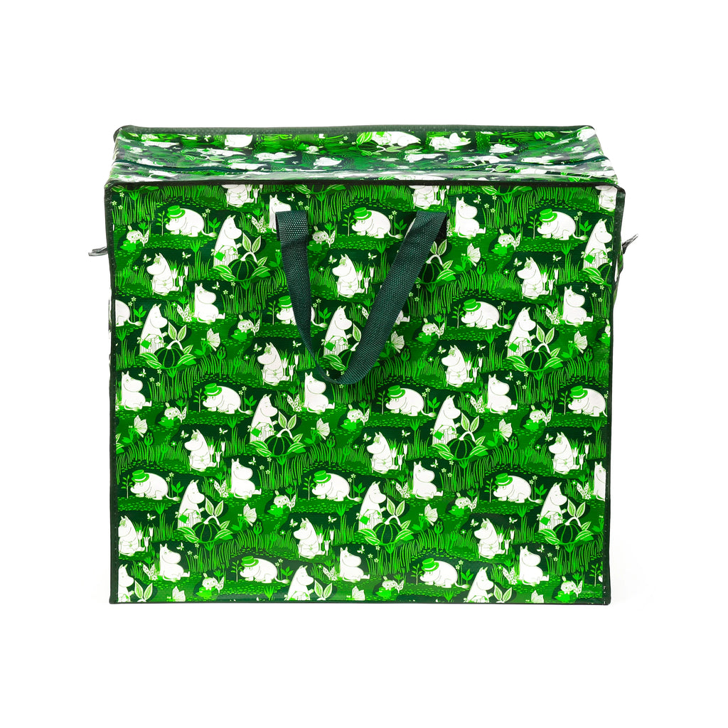 Angled front view of a green laundry and storage bag with a white Moomin characters, plants, and butterflies pattern. It features dark green fabric handles and a zipped top closure.
