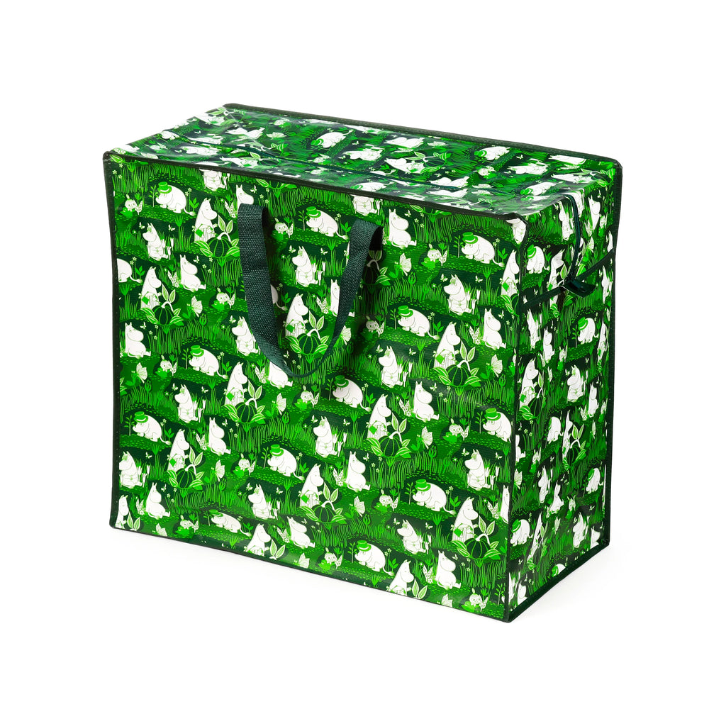 Angled view of a green laundry and storage bag with white Moomin characters and garden pattern, featuring dark green fabric handles and a top zip closure.