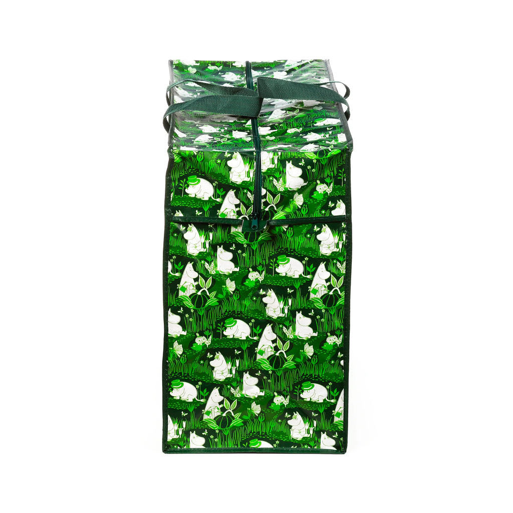 Upright green laundry and storage bag with Moomin Garden Life pattern, showing white characters, plants, and butterflies, with a top zipper and tied dark green handles.