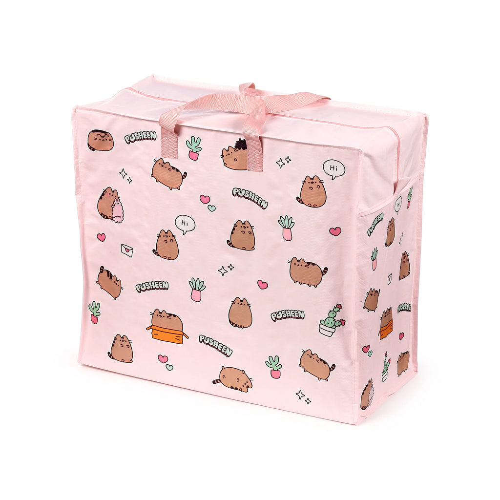 Angled view of a pale pink laundry and storage bag, featuring a playful pattern of cartoon cat characters, potted plants, hearts, and stars. It has pink fabric handles tied in a bow and a zip closure on top.