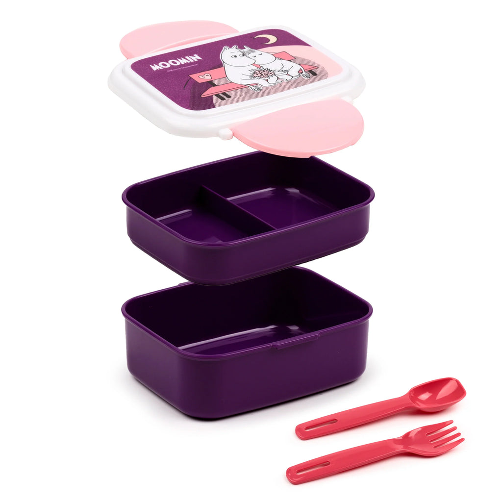 Angled view of a disassembled bento clip lock lunch box, featuring a dark purple body, a white lid with pink clips and a Moomin character design, and separate pink fork and spoon. The top compartment has an internal divider.