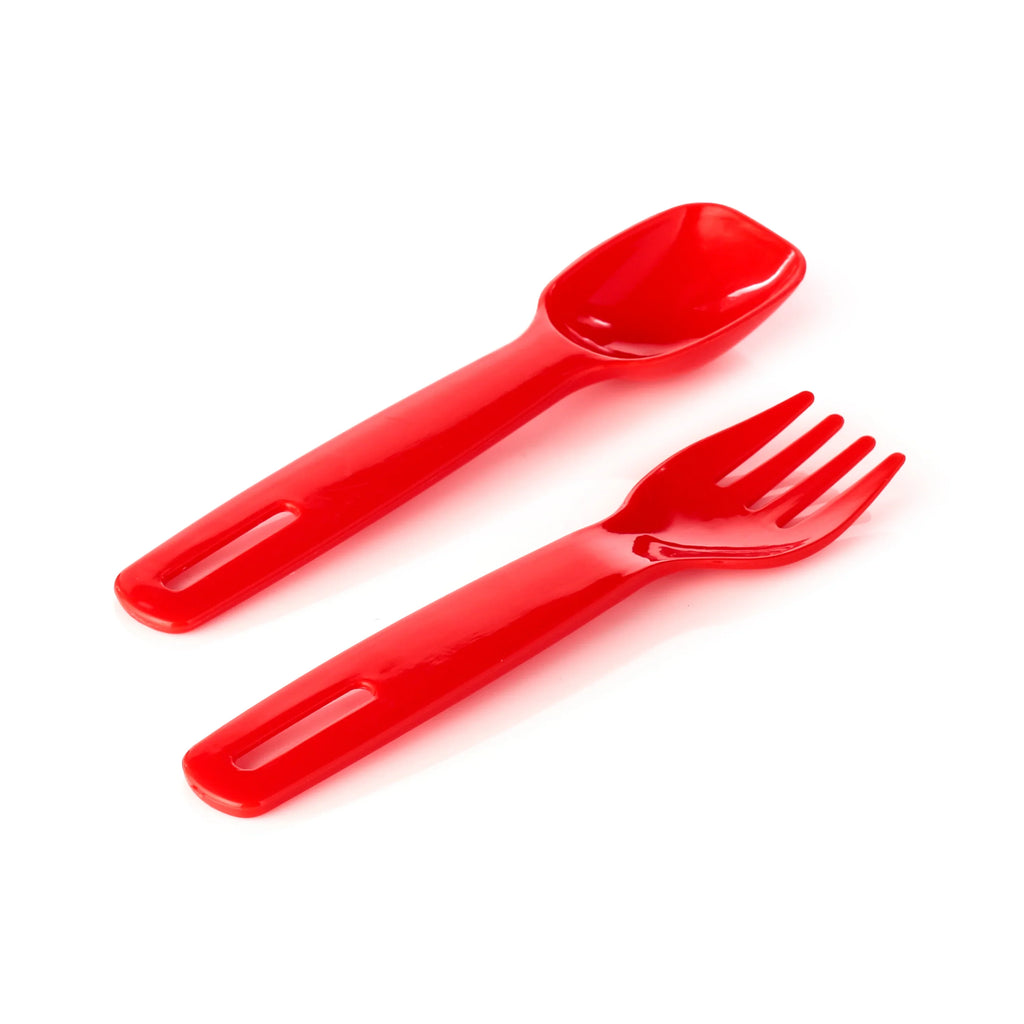 Red plastic spoon and fork, both with cutout slots in their handles, shown from an angled overhead view on a white background.
