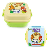 Angled view of a two-tone light cream and green bento clip lock snack lunch box, its lid decorated with a cartoon wild animal design featuring a monkey, tiger, panda, and red panda. A light blue retail box for the product is also visible.