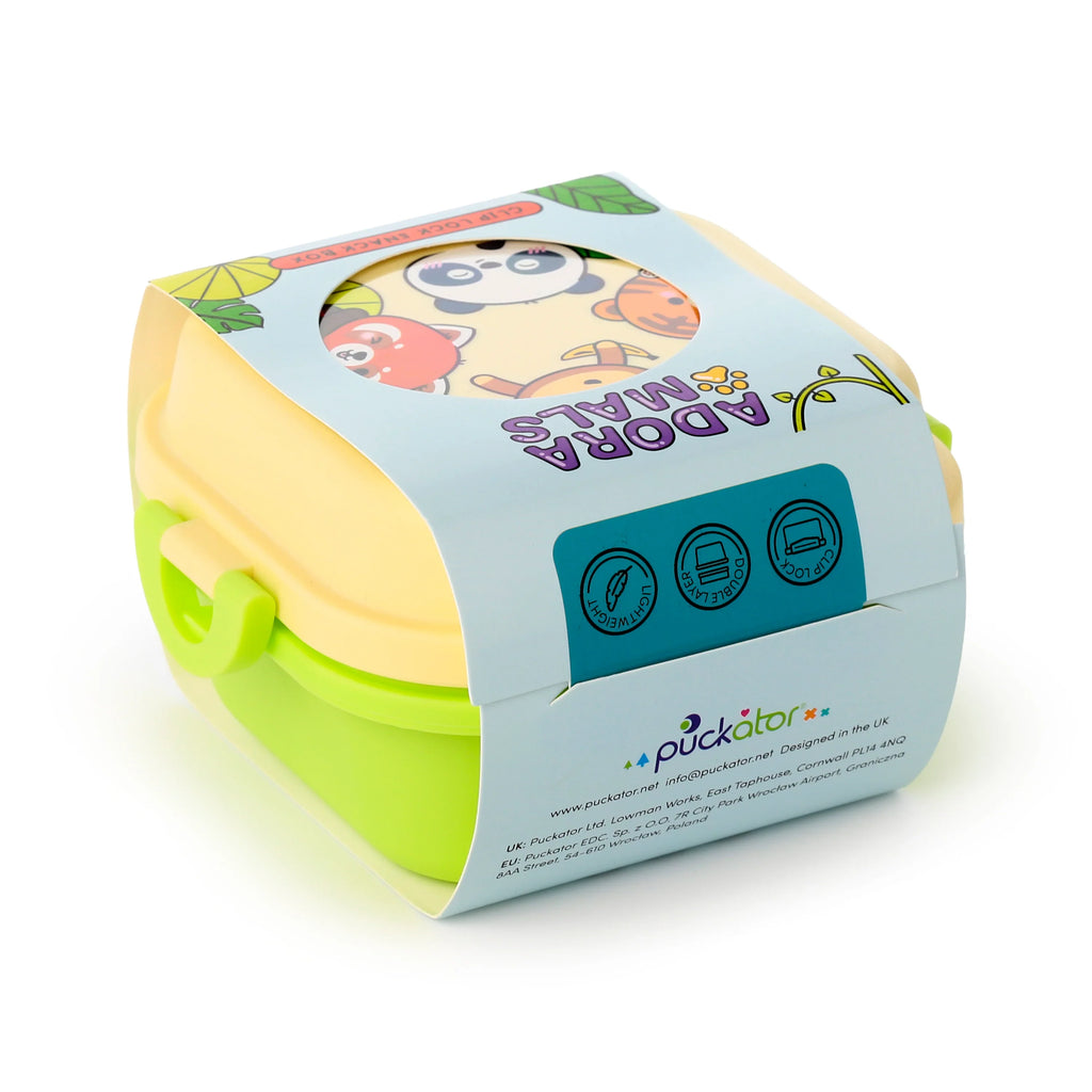 Angled view of a cream and lime green two-tier bento clip lock snack lunch box. Its lid features a colourful cartoon wild animal design, partially visible through a light blue product packaging sleeve.