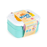 Angled view of a mint green and white clip lock bento lunch box with a cartoon cat design and 'Beans & Co' on the lid, featuring a product tag showing dual compartments, cutlery, and purple clips.