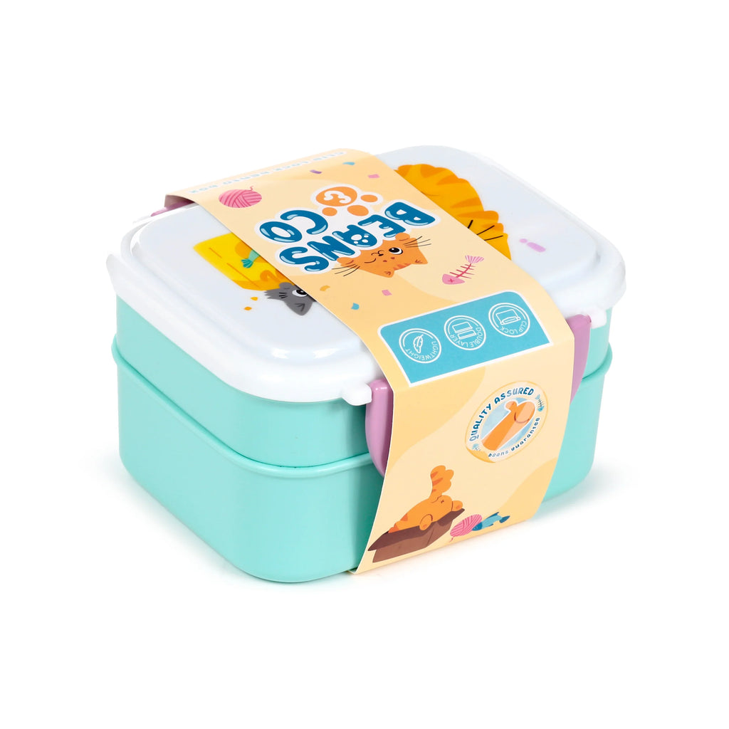 Angled overhead view of a two-tiered aqua and white bento clip lock lunch box with purple clips, wrapped in an orange paper band decorated with 'Beans & Co' text, cartoon cat illustrations, and icons, including one for cutlery.