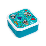 Angled view of a square teal lunch box, its lid displaying a vibrant Day of the Dead design with three colourful sugar skulls, a purple diamond, a red heart, and a yellow cross.