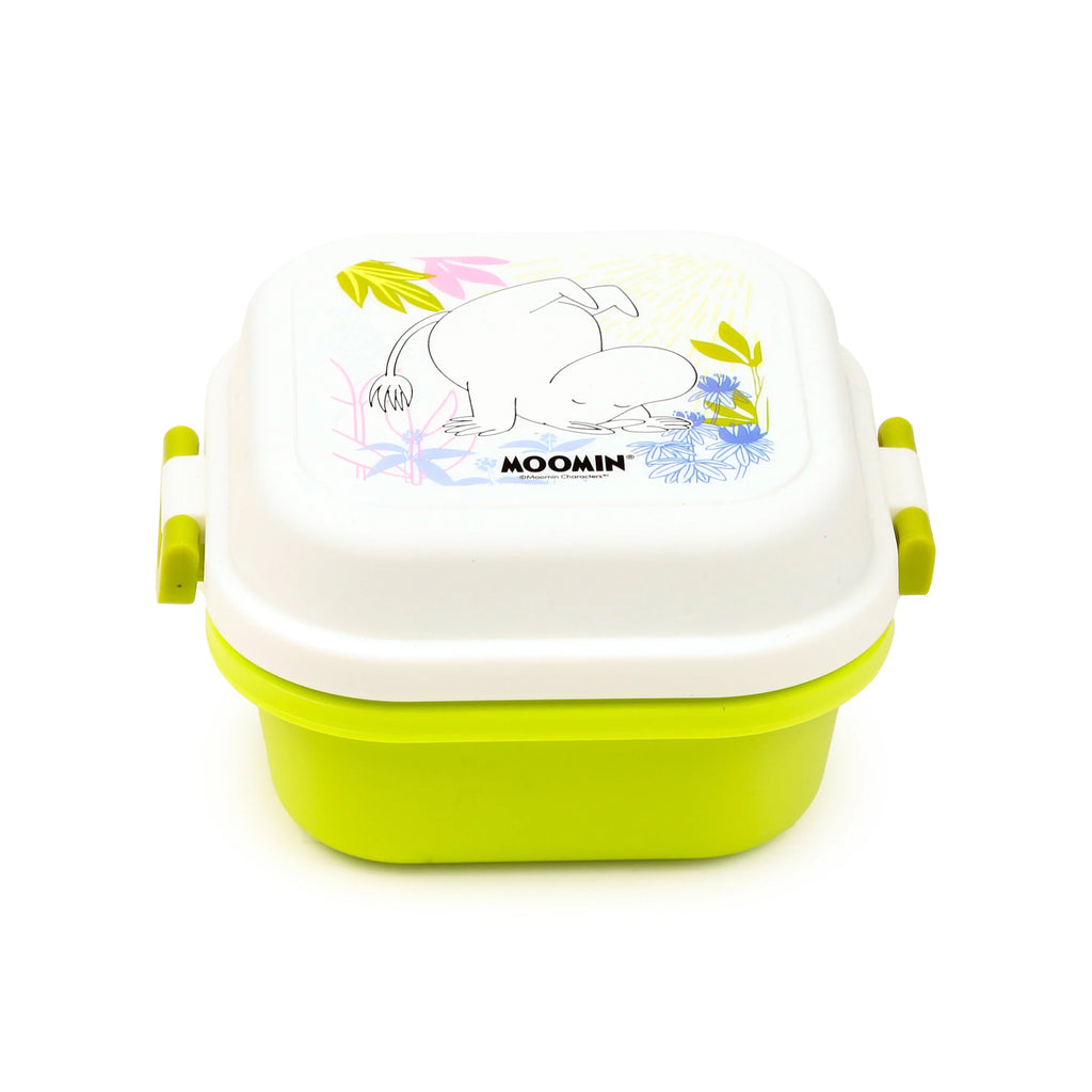 Angled view of a white and lime green Bento clip lock snack lunch box, featuring a Moomin character illustration and colourful floral patterns on the lid.