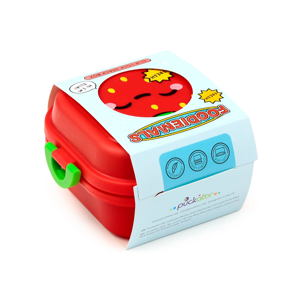 Angled view of a red Bento clip-lock snack lunch box with a green clip, showcasing the Elidi the strawberry character design on the lid. Light blue packaging partially wraps the box, displaying 'FOODIEMALS' and 'FRESH' text.
