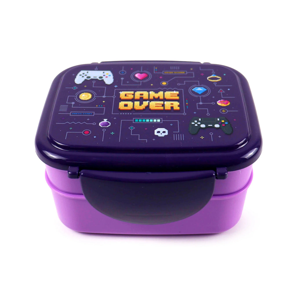 Angled view of a purple bento clip lock lunch box, featuring a dark purple lid with a pixelated 'Game Over' gaming design, including controllers, a skull, and coins, atop a lighter purple base.