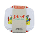 Overhead view of a white Pippi Longstocking Bento clip lock lunch box, featuring orange side clips. A decorative paper band wraps around the box, displaying Pippi LONGSTOCKING text, and icons for clip lock, double layer, and lightweight features. Colourful cartoon illustrations are partially visible on the lid beneath the band.