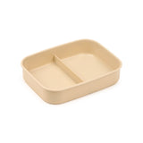Angled view of a rectangular, light beige bento lunch box base with two internal compartments.