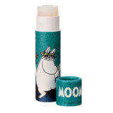 Angled view of a paper stick lip balm. The translucent, pale cream balm is extended from its teal tube, which features a white Moomin character illustration. The separate teal cap is placed alongside, displaying 'MOOMIN' in white text.