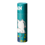 Front view of a cylindrical teal paper stick lip balm featuring an upside-down white Moomin character illustration amongst yellow flowers and green foliage.