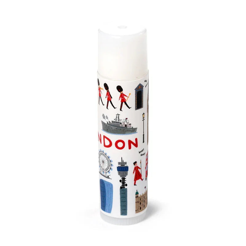 Front view of a white stick lip balm with a clear cap, decorated with colourful London-themed illustrations featuring Royal Guards, the London Eye, and iconic London buildings.