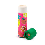 Angled view of an open Summer Fruits paper stick lip balm. The light-coloured balm is exposed from a vibrant pink tube featuring illustrations of pineapple, peach, lemon, orange, and watermelon. The green cap lies detached next to it, showing an internal peach design and '100% Plastic Free, Recyclable' text.