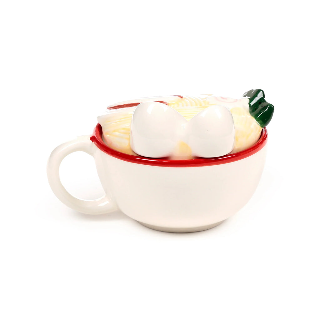 White ceramic lidded mug with red rim, featuring a ramen noodle design lid with white egg shapes, pink swirls, and green garnish, angled view.