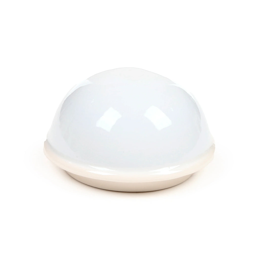 Angled view of a glossy white ceramic dome-shaped mug lid.