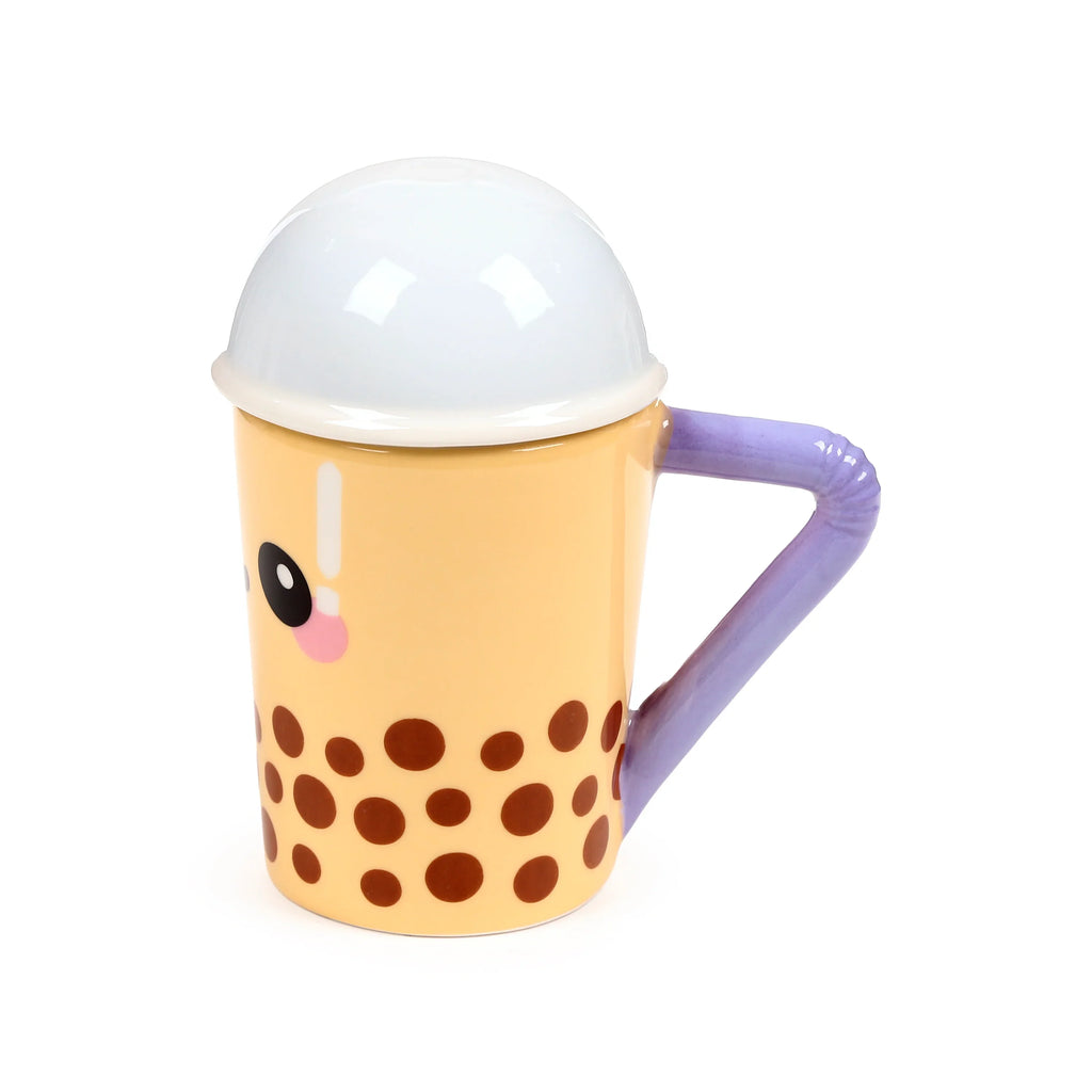 Angled view of a yellow ceramic lidded mug, designed as a bubble tea cup with a cartoon face, brown boba-like spots, and a purple straw handle.