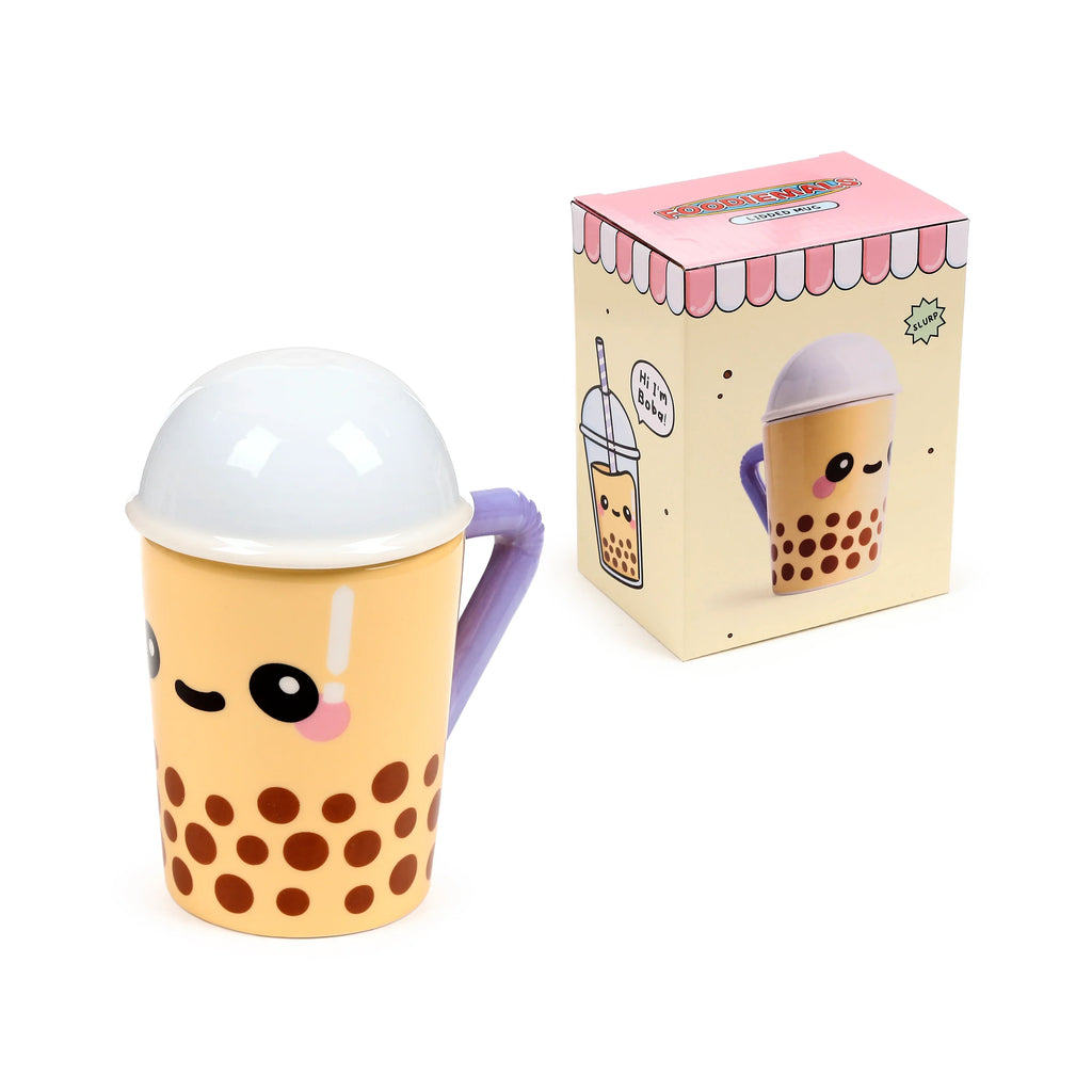 Angled view of a light beige ceramic lidded mug with a kawaii face, brown polka dots, a white domed lid, and a purple handle. Beside it, its packaging box displays boba tea cup illustrations.