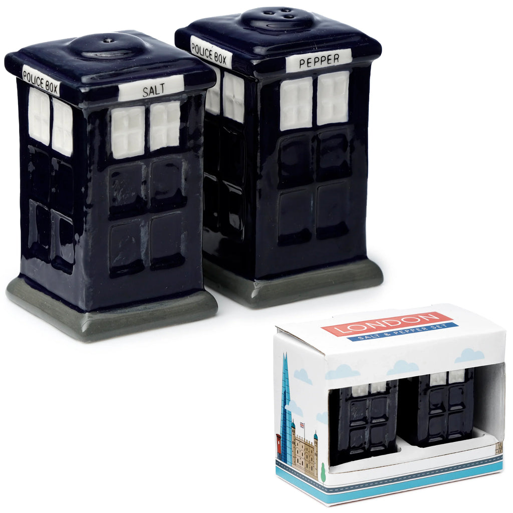 Angled view of two dark blue ceramic Police Box salt and pepper shakers, one labelled 'SALT' and the other 'PEPPER', displayed next to their white packaging box featuring London landmark illustrations.