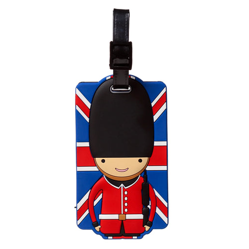 Front view of a PVC luggage tag depicting a London Guardsman character in a red tunic and black bearskin hat, set against a Union Jack flag in red, white, and blue colours.