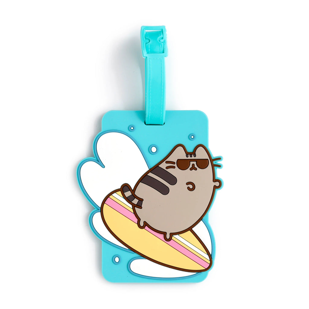 Front view of a light blue PVC luggage tag featuring a winking grey cartoon cat wearing sunglasses and lying on a yellow surfboard, with white water splashes and a turquoise strap.
