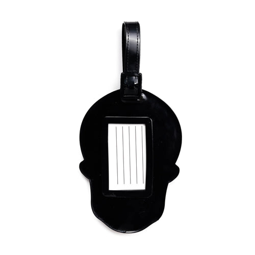 Black PVC skull-shaped luggage tag, back view showing a white address insert with lines and a black strap.