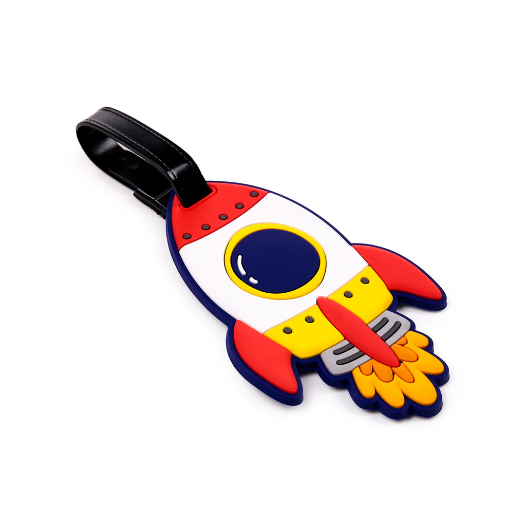 Angled view of a red, white, blue, and yellow rocket-shaped PVC luggage tag with a black strap.