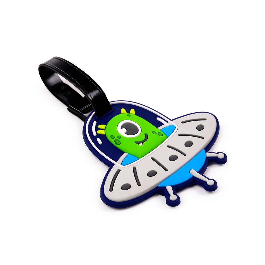 Angled front view of a PVC luggage tag, depicting a colourful cartoon green one-eyed alien inside a blue and grey flying saucer, with a black strap.