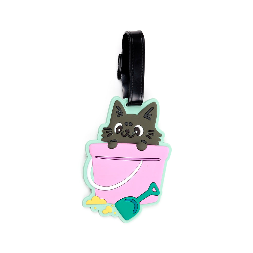 Front view of a colourful PVC luggage tag featuring a grey cartoon cat peeking from a pink beach bucket, alongside a green spade and yellow sand, attached to a black strap.