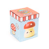 Angled view of the ceramic money box packaging. The light blue box shows a cute red and yellow mushroom toadstool with a smiley face, topped with an orange scalloped lid featuring 'Money Box' text.