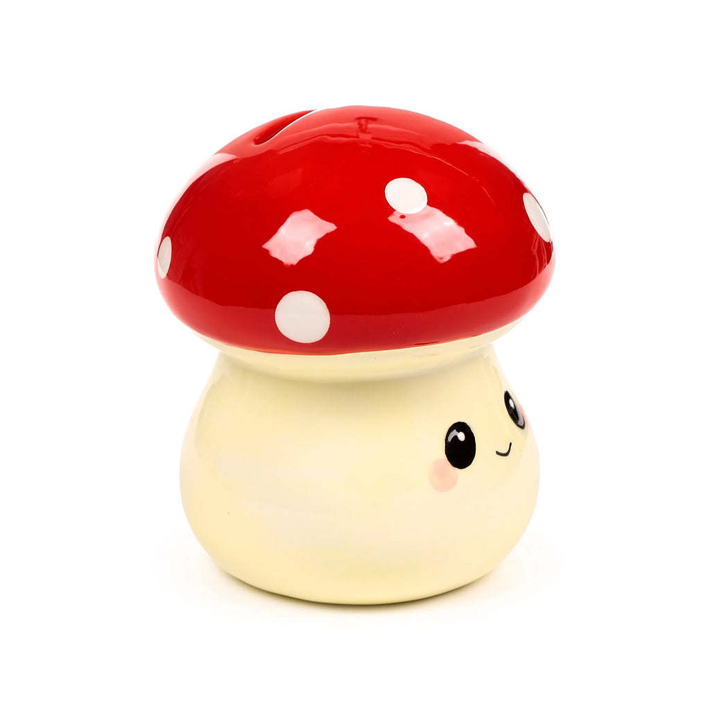Cute ceramic money box shaped like a red and cream mushroom, with white spots, a smiling face, and a coin slot.