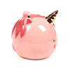 Pink ceramic unicorn money box, angled to reveal closed eyes, rosy cheeks, a golden horn, dark pink mane, and coin slot on top.