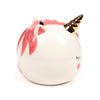 Angled view of a white ceramic unicorn money box, featuring a pink mane, gold horn, painted closed eye, pink cheek blush, and a coin slot on top.
