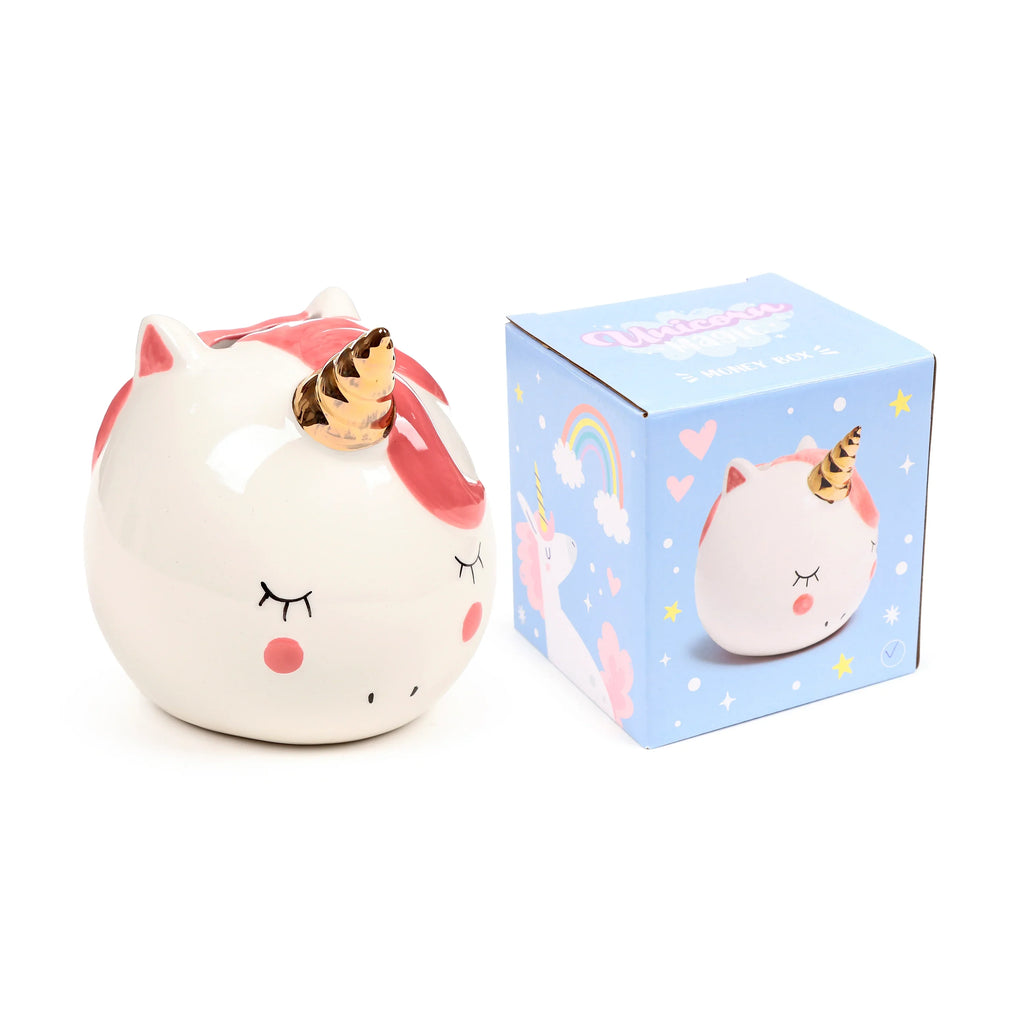 Angled view of a white ceramic unicorn money box with a golden horn, pink ears, cheeks, and mane, featuring closed eyes, alongside its blue patterned presentation box.