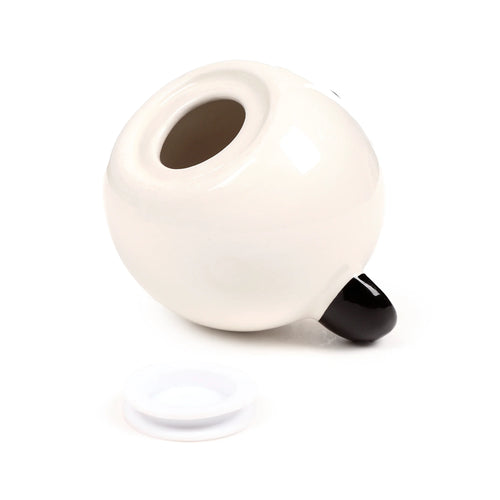Angled view of a white ceramic panda money box, showing the underside coin retrieval opening and a separate white stopper.