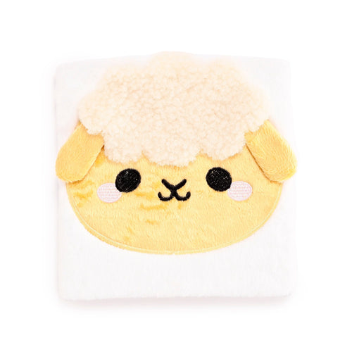 Front view of a plush notebook featuring a yellow Adoramals sheep face with black embroidered eyes, nose, pink cheeks, and cream-coloured fluffy wool.