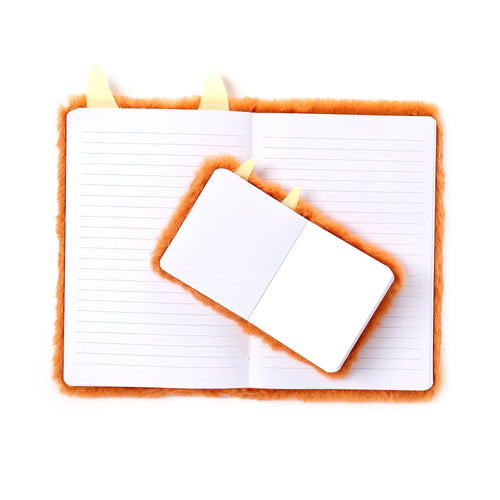 Overhead view of an open orange plush A5 notebook with lined pages, featuring a smaller open mini notebook, both having light yellow horn-like details.